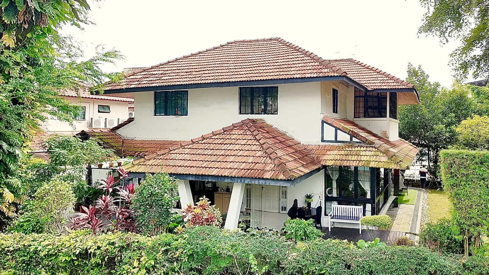 40 Margoliouth Road, a two-storey bungalow with a clay-tiled roof behind a hedge and garden