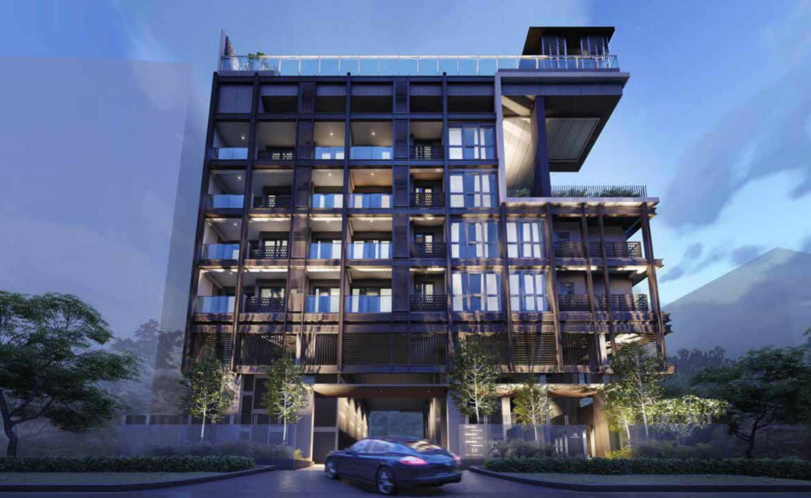 33 Residences: the eight-storey block with its dark frame and timber screens at the main entrance, at dusk