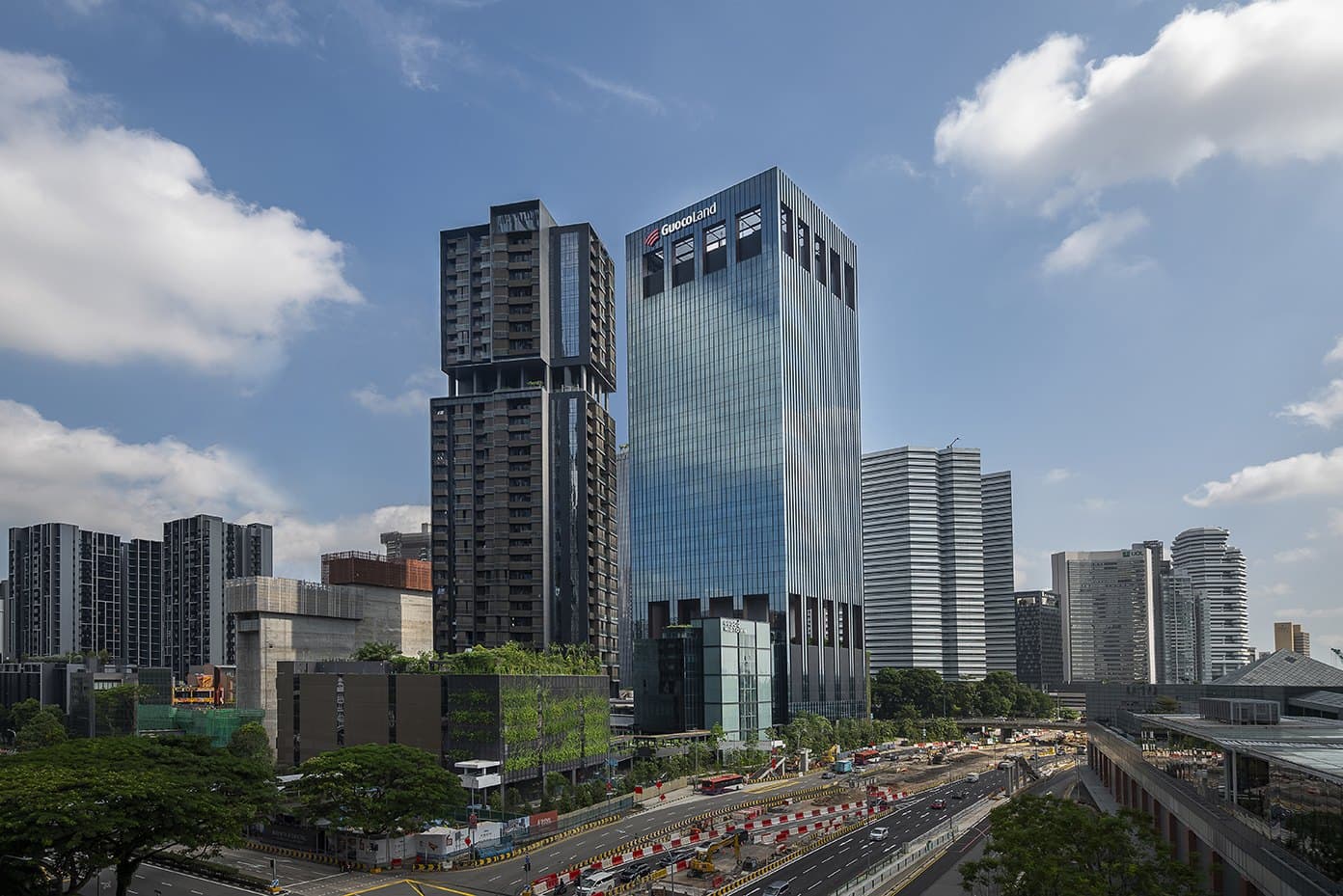 Photograph of Guoco Midtown from the Suntec City side: the dark 33-storey Midtown Bay tower on the left, with its sky terrace gap two thirds of the way up, beside the glass Guoco Midtown office tower