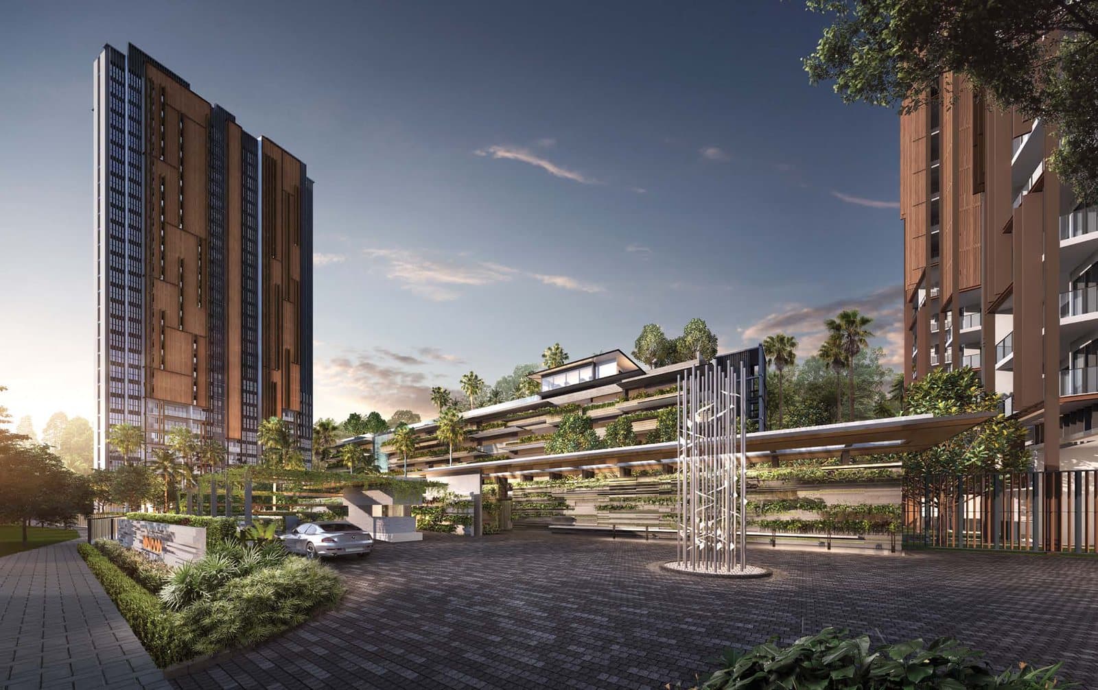 Artist's impression of the arrival court at Midwood at dusk: a paved driveway and a tall sculpture in front of terraced planting, with the two 29-storey towers in timber-brown and dark grey rising on either side