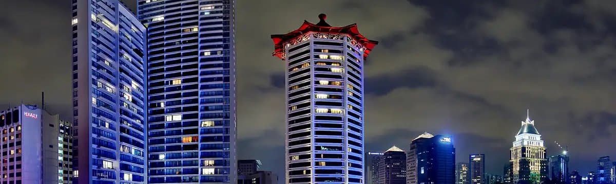Photo of Scotts Square at night: its two glass towers on Scotts Road, beside the Grand Hyatt and across from the Marriott's pagoda roof