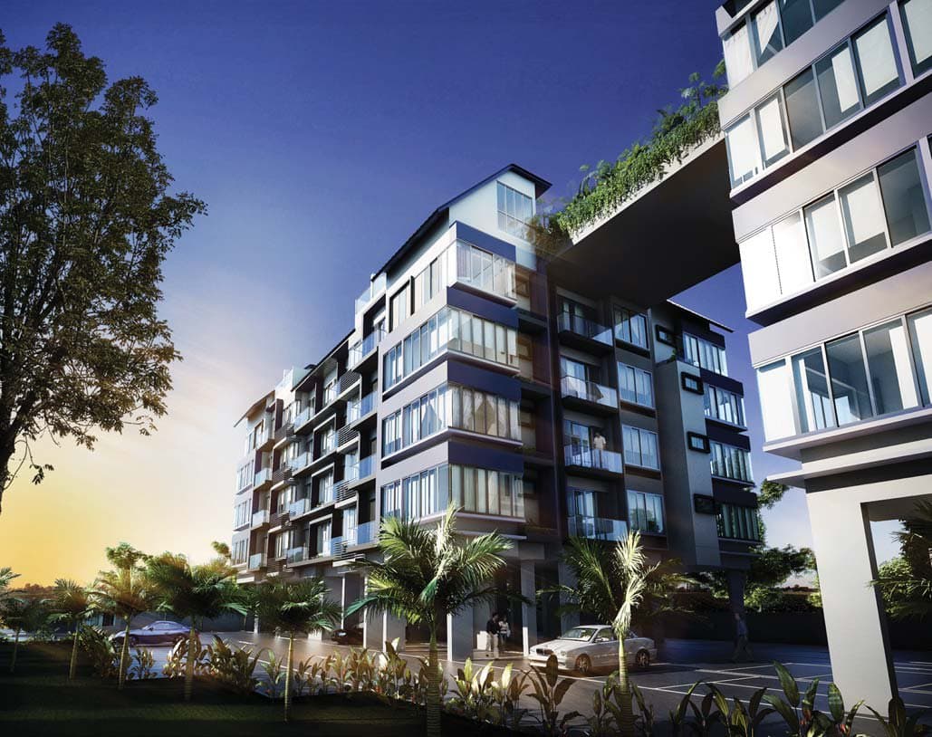 Suites De Laurel: the 5-storey block with glass balconies and a green roof at dusk