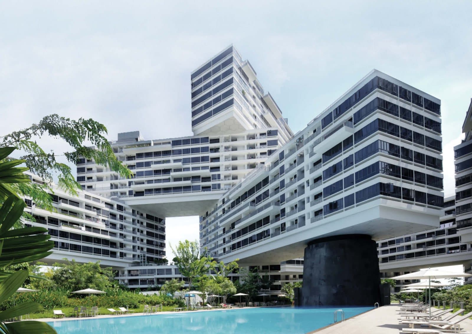 The Interlace seen from the pool: six-storey blocks stacked across one another above a round black column